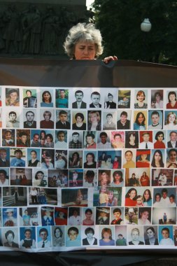 Beslan terörist saldırı karşı bir poster yıldönümünde öldürülen çocuklar resimlerle Moskova yas Mitingin bilinmeyen katılımcı
