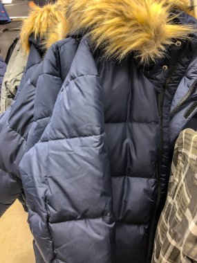 Mağazadaki askıda kadın kıyafetleri - paltolar, ceketler, bluzlar