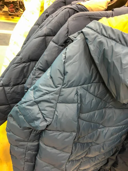 Mağazadaki askıda kadın kıyafetleri - paltolar, ceketler, bluzlar