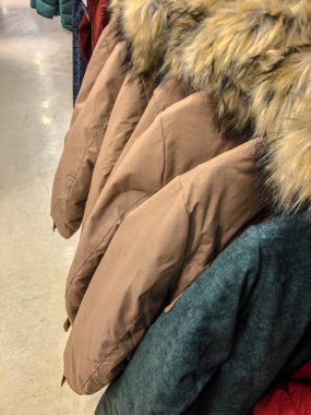 Mağazadaki askıda kadın kıyafetleri - paltolar, ceketler, bluzlar