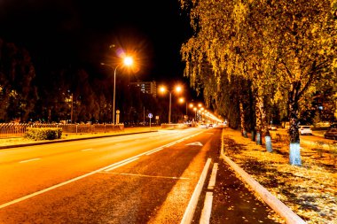 Bir gece şehrinin sanatsal fotoğrafı. Kolay bulanıklaştırma, gerçekçi olmayan renkler, pastörizasyon etkisi