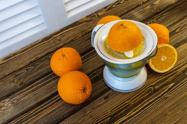 Fotoğraf, Düz Portakallar ve Meyve Suyu ahşap kahverengi arka planda