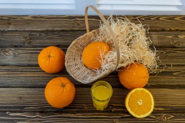 Fotoğraf, Flat Lay Portakallı sepet ve portakal suyu dolu sürahi, ahşap kahverengi arka planda.