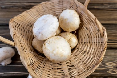 natürmort, mantar şampiyonlarının yemek fotoğrafı. Mantarlar bütün ve doğranmış, sepet dolusu mantarlar. Ahşap arka planda