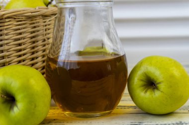 Yeşil elma, elmalı sepet ve ahşap arka planda elma suyu.