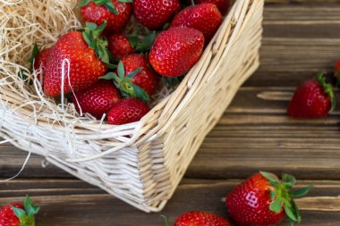 Sepette çilek ve ahşap arka planda masa.