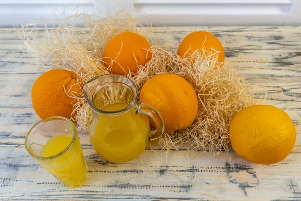 Stillleben Mit Orangen Korb Und Glaskrug Mit Saft Auf Altem — Stockfoto