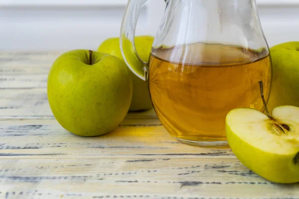 Grüne Äpfel Und Krug Mit Glas Mit Apfelsaft Auf Holzgrund — Stockfoto