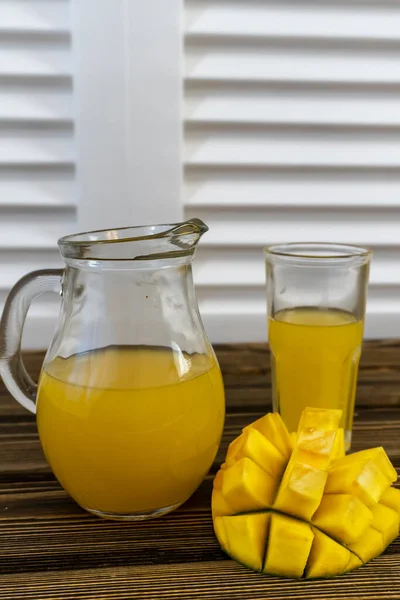 Stillleben Mit Mango Und Glaskrug Mit Saft Auf Altem Holzgrund — Stockfoto