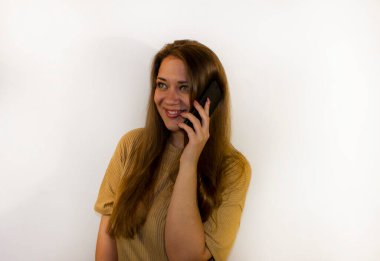 Akıllı telefonlu genç ve güzel bir kadın, bir mesaj yazıyor, selfie çekiyor, iletişim kuruyor.