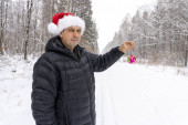 muž v Santa klobouku s vánoční ples v zimě v lese