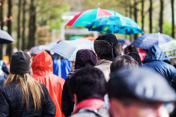 Multidões de pessoas em movimento enquanto chove — Fotografia de Stock