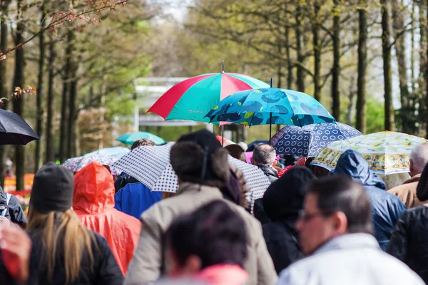 Multitudes de personas en movimiento mientras llueve — Foto de Stock