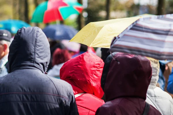 Menigte van mensen onderweg, terwijl het regent — Stockfoto