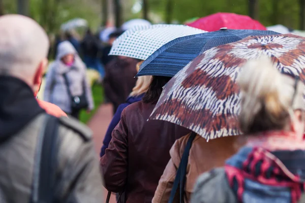Multidões de pessoas em movimento enquanto chove — Fotografia de Stock