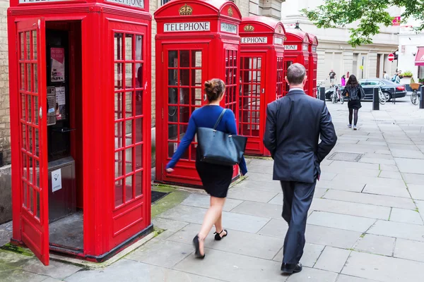 Transeúnte en Covent Garden, Londres, Reino Unido, en las tradicionales cabinas telefónicas rojas — Foto de Stock