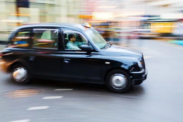 夜の動きのぼやけでロンドンのタクシー — ストック写真