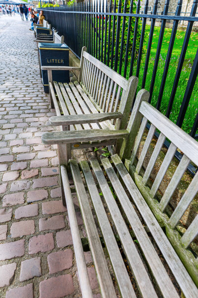 Park benches along the Thames promenade outside of the Tower of London in London, UK