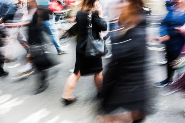 Multitud de personas cruzando una calle de la ciudad en desenfoque movimiento — Foto de Stock