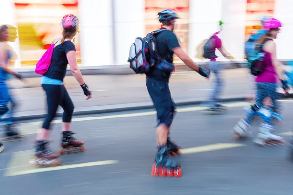 Pessoas patinadoras em uma rua da cidade — Fotografia de Stock