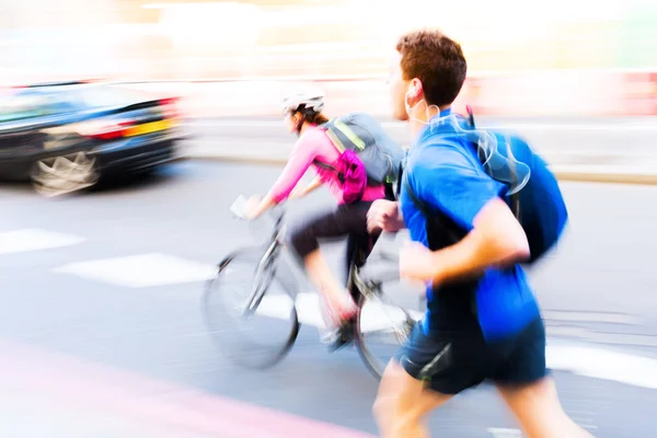Corredor e ciclista no trânsito da cidade — Fotografia de Stock