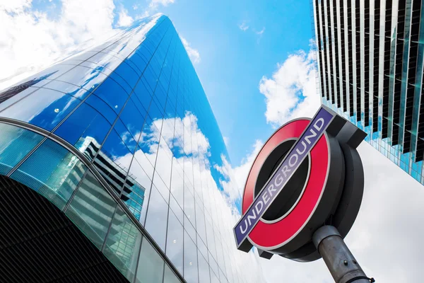 Underground sign with skyscrapers in London, UK — Stock Photo, Image