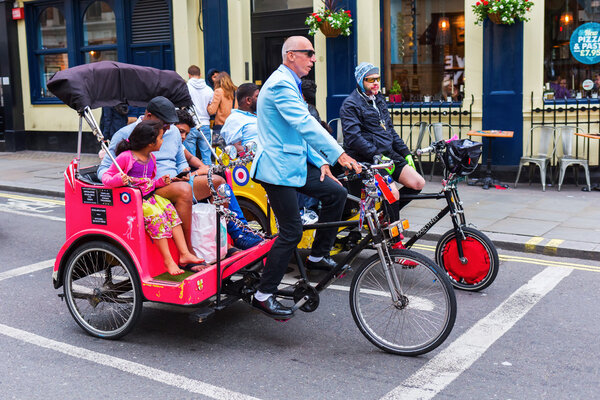 people with cycle rickshaws in London, UK