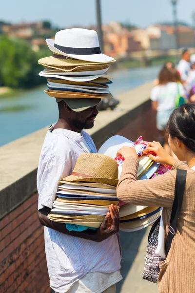 Mörkhyade mannen som säljer solhattar i Florens, Italien — Stockfoto