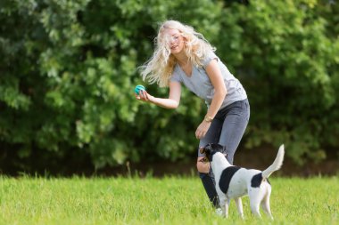 genç kız bir köpekle oynar