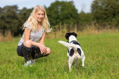genç kız bir köpekle oynar