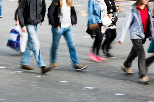 Personas mostradas en movimiento borroso cruzar una calle —  Fotos de Stock