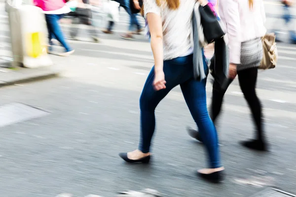 Mensen getoond in motion blur oversteken van een straat — Stockfoto