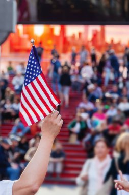 New York 'taki Times Meydanı' nda bir kalabalığın önünde Amerikan bayrağı tutan adam.