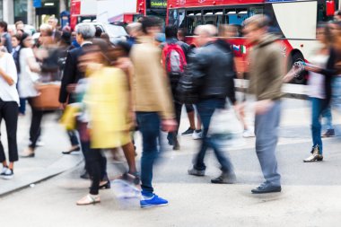 Londra'da bir caddeden karşıya insanlar Hareket Bulanıklığı