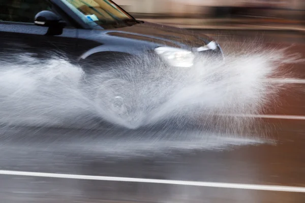 Conducir un coche en una calle mojada —  Fotos de Stock