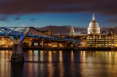 Millennium Bridge and St Pauls Cathedral in London at night clipart