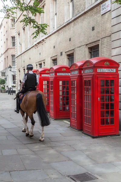 Red phone boxés and a mounted police officer in London — Zdjęcie stockowe