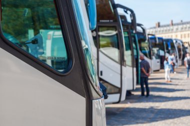 Coaches in a row at a travel destination clipart