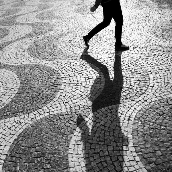 Shadow of a person on cobblestones