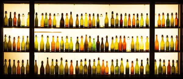 Viejas botellas de cerveza en un escaparate iluminado de una cervecería en Colonia —  Fotos de Stock