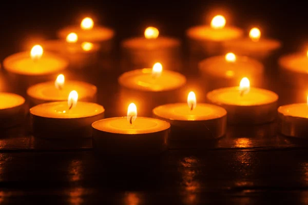 Čajové svíčky hoří ve tmě — Stock fotografie