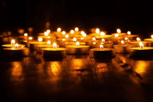 Mass of burning tea lights in the dark — Stock Photo, Image