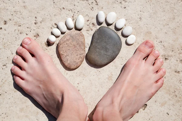 Pie de niña y pies de piedra —  Fotos de Stock