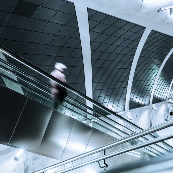 Mann verschwommen auf Rolltreppe einer modernen U-Bahn-Station — Stockfoto