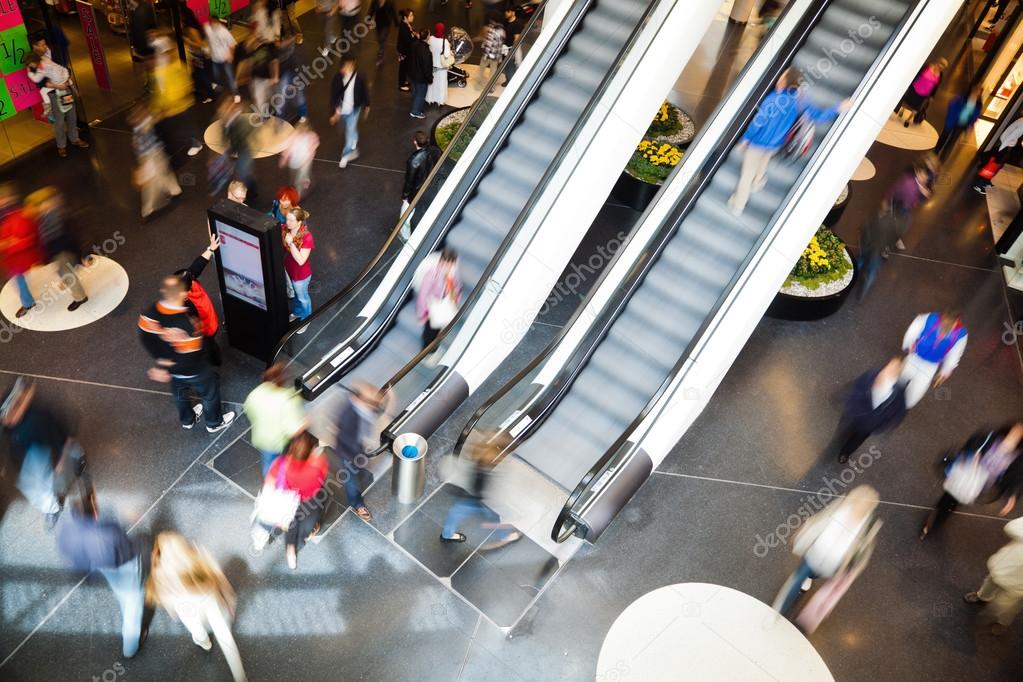 People in motion blur on escalators