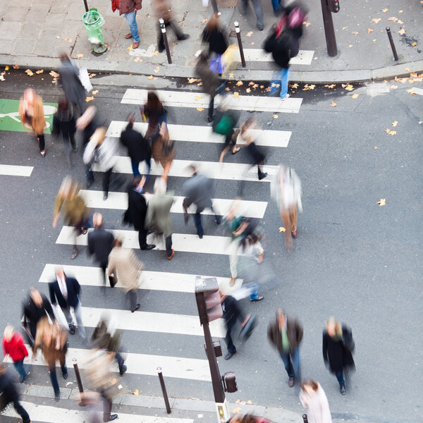 Aerial view of a crowd of people crossing a city street at a pedestrian crossing