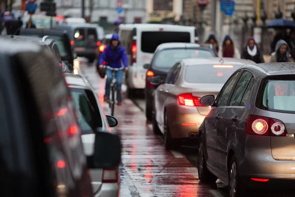 Coches en un atasco de tráfico en hora punta en la ciudad lluviosa — Foto de Stock