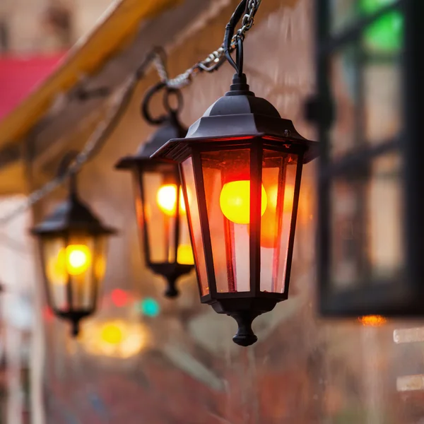 Alte Laternen mit bunten Glühbirnen im Zelt eines Weihnachtsmarktes — Stockfoto