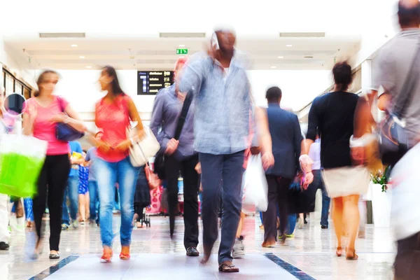 Människor i en shopping passage i rörelse oskärpa — Stockfoto