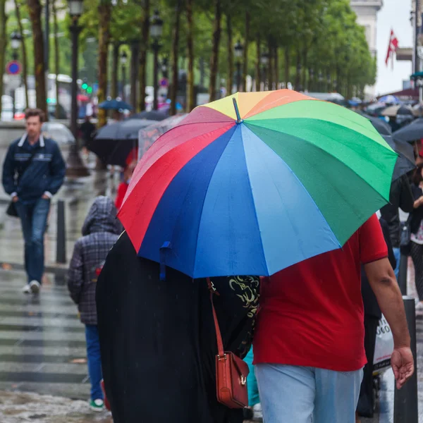 Färgglada regn paraply på upptagen trottoaren — Stockfoto
